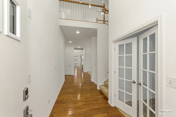 a view of a hallway with wooden floor and staircase