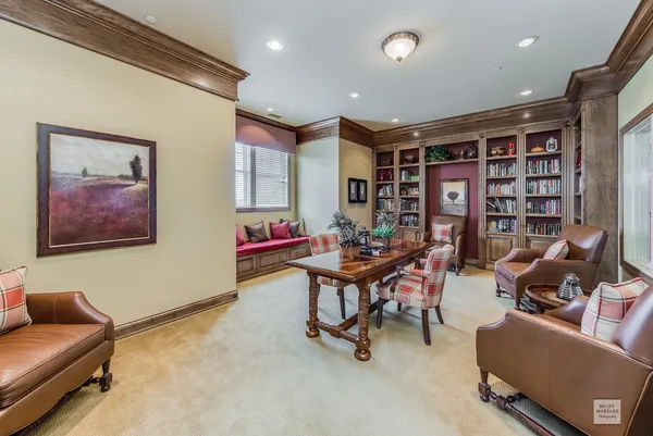 a living room with furniture and a book shelf