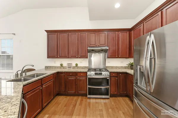a kitchen with stainless steel appliances granite countertop a sink stove and refrigerator