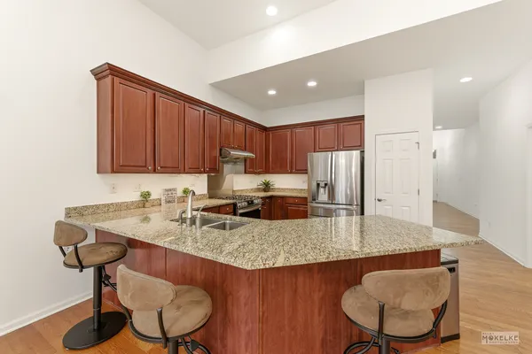 a kitchen with stainless steel appliances granite countertop a sink refrigerator and cabinets