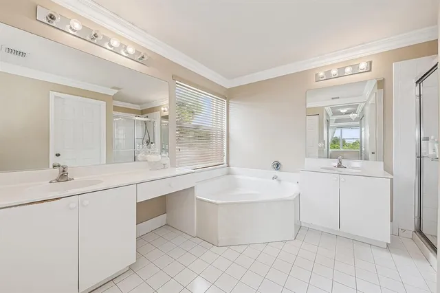 a spacious bathroom with a double vanity sink mirror and bathtub