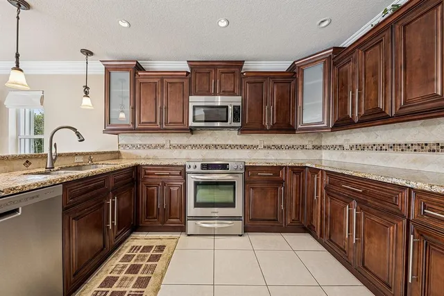 a kitchen with stainless steel appliances granite countertop a stove sink and cabinets