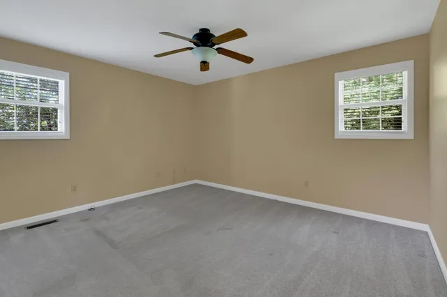 an empty room with a window and a fan