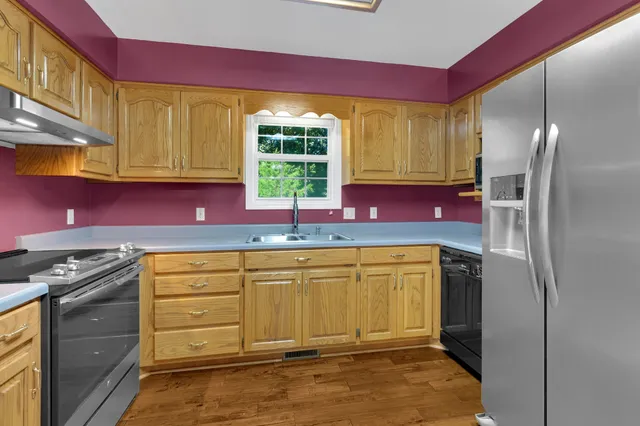 a kitchen with stainless steel appliances granite countertop a refrigerator and a stove