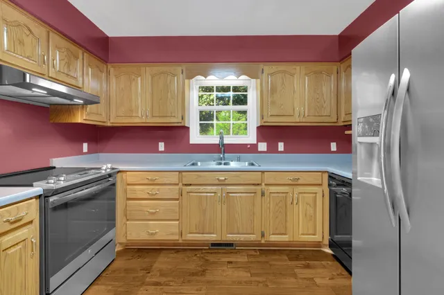 a kitchen with stainless steel appliances granite countertop a refrigerator sink and cabinets