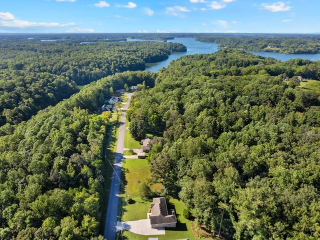 an aerial view of residential houses with outdoor space and trees