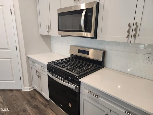 a kitchen with stainless steel appliances a stove microwave and sink