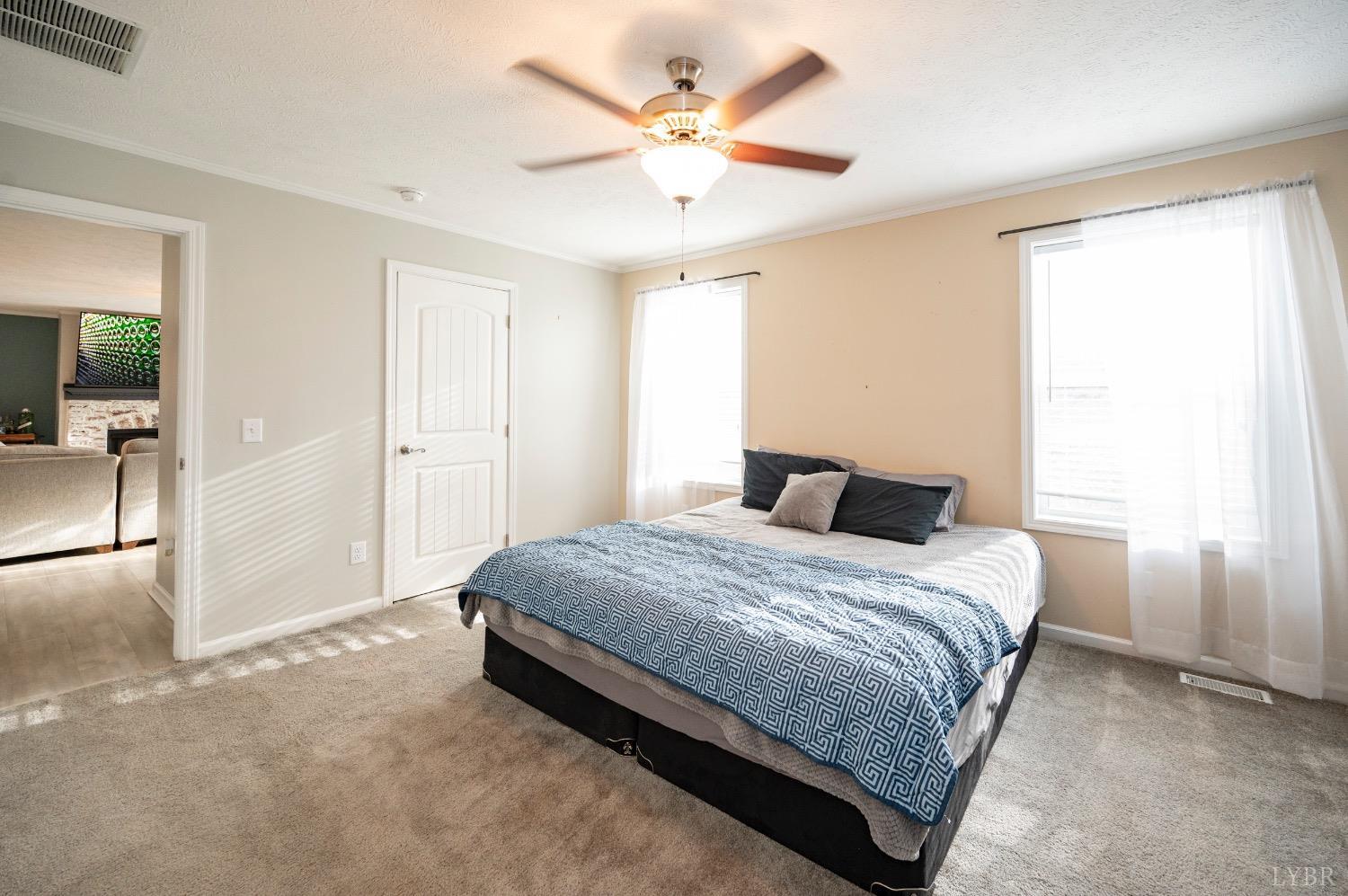 563 Evington Road Evington, VA 24550 - Photo 15 of 17 a spacious bedroom with a bed and a chandelier