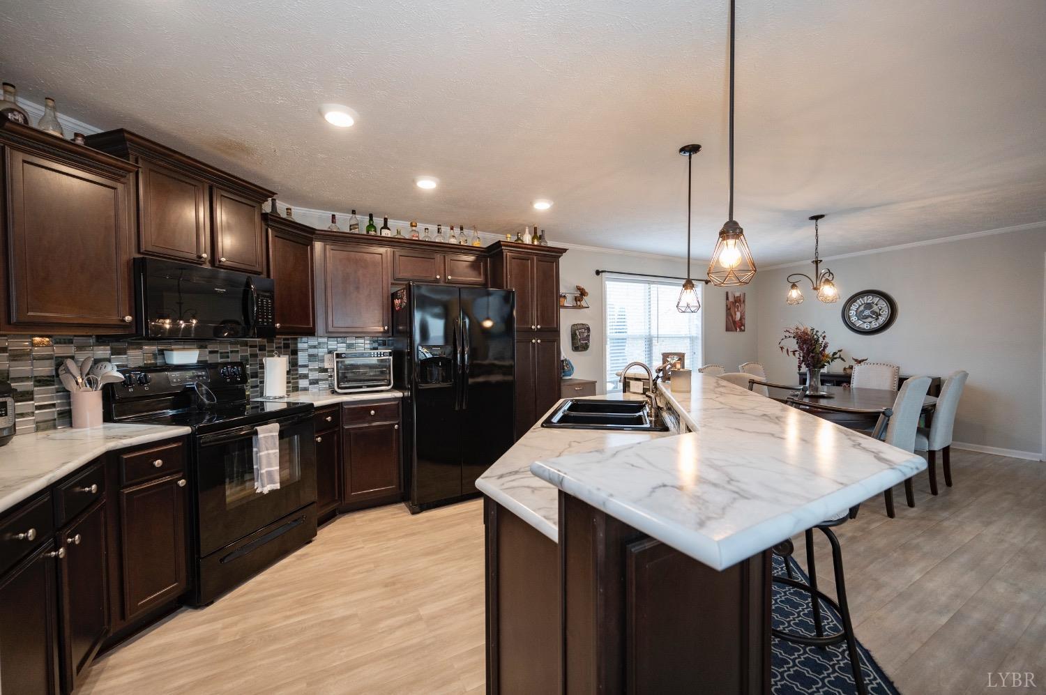 563 Evington Road Evington, VA 24550 - Photo 6 of 17 a kitchen with a kitchen island wooden cabinets and refrigerator