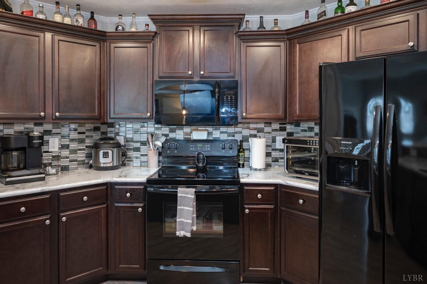 563 Evington Road Evington, VA 24550 - Photo 8 of 17 a kitchen with stainless steel appliances granite countertop a refrigerator and a stove top oven