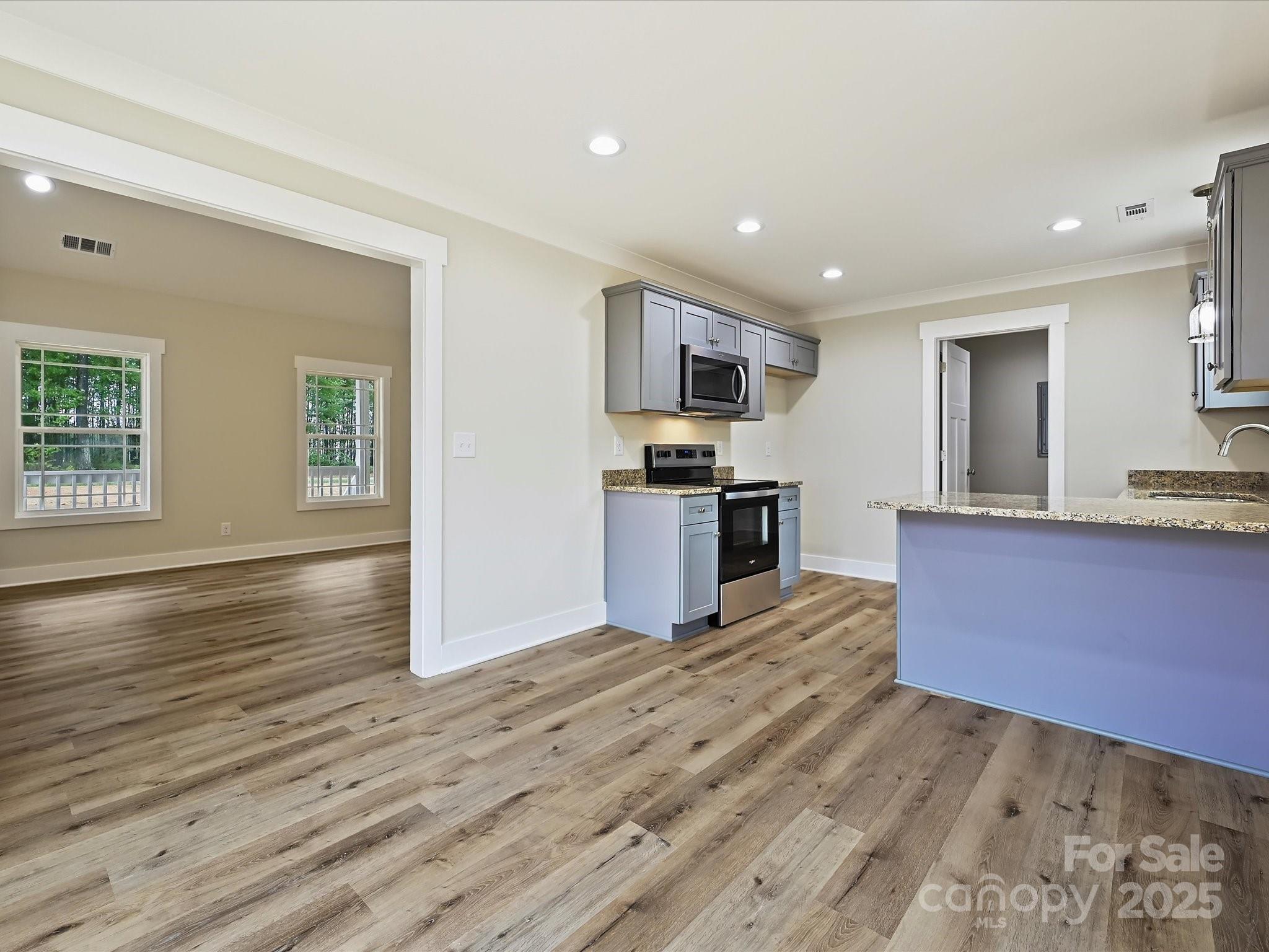 254 Old Pinckney Road York, SC 29745 - Photo 5 of 26 a kitchen with stainless steel appliances granite countertop a stove top oven a sink dishwasher a refrigerator and cabinets with wooden floor