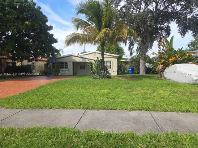 a view of a house with a yard and large trees