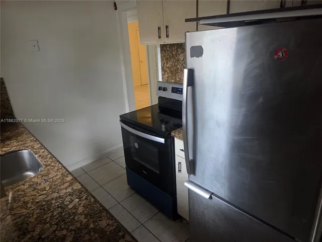 a kitchen with a refrigerator and cabinets