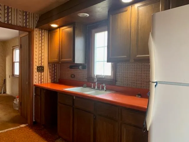 a kitchen with stainless steel appliances granite countertop a sink a stove and a refrigerator