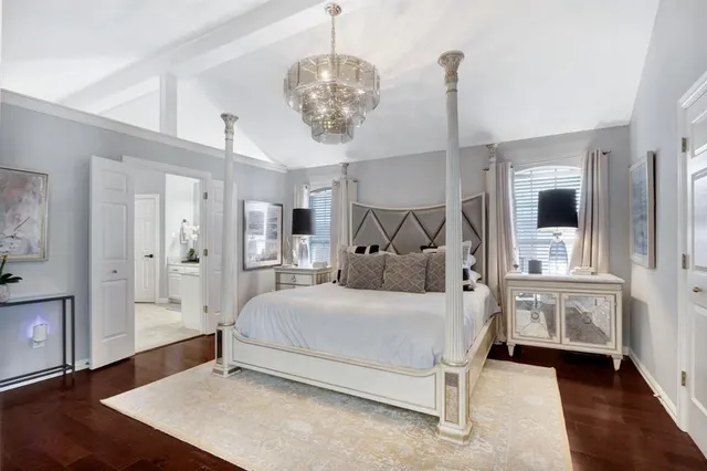 a bedroom with a large bed and a chandelier