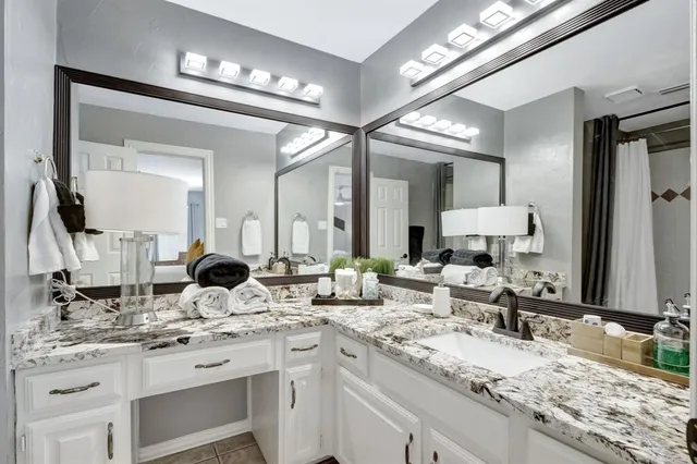 a bathroom with double vanity and a mirror