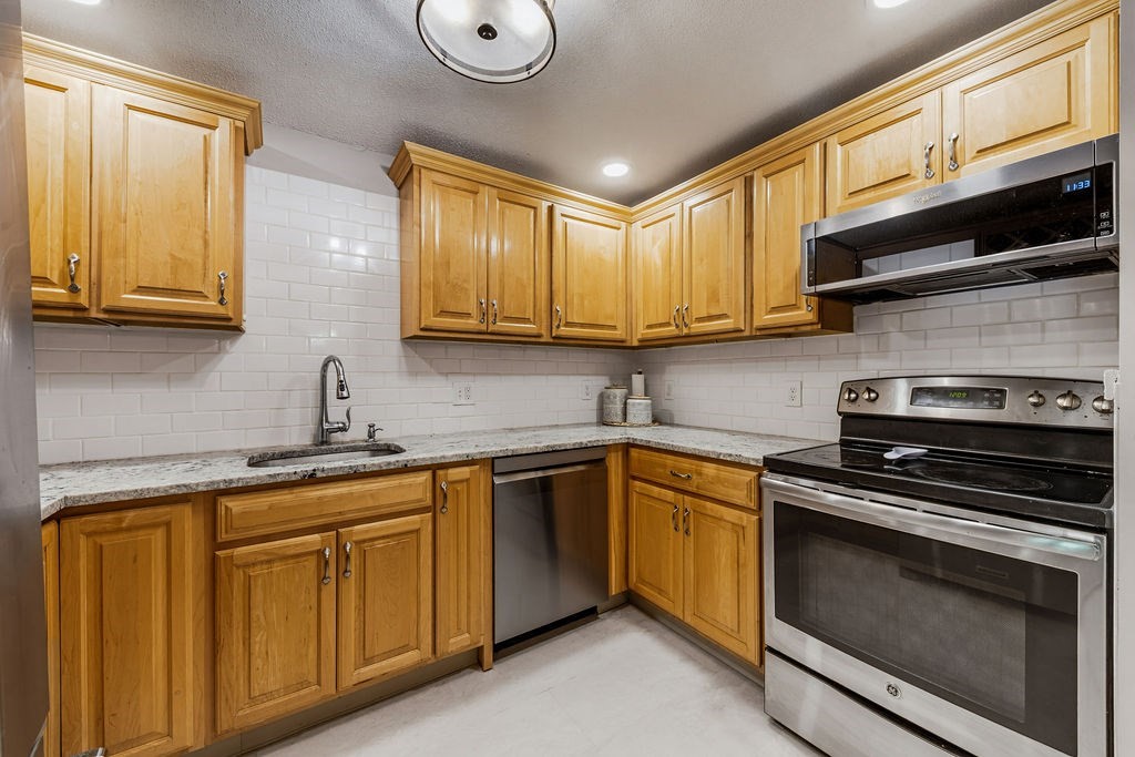 10 Erick Road, Unit 42 Mansfield, MA 02048 - Photo 15 of 33 a kitchen with stainless steel appliances granite countertop a sink a stove and cabinets