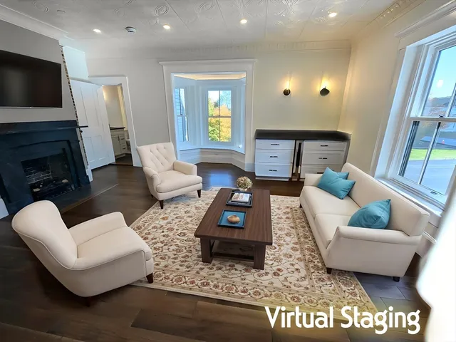 a living room with furniture a fireplace a flat screen tv and a large window