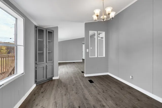a view of a room with wooden floor chandelier and entryway