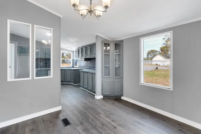 an empty room with windows and cabinet