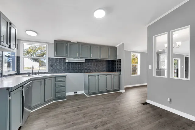 a kitchen with granite countertop a stove a sink and a window