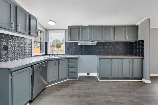 a kitchen with granite countertop a sink and cabinets