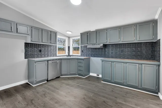 a kitchen with granite countertop a sink stainless steel appliances and cabinets