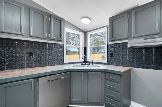 a kitchen with stainless steel appliances granite countertop a sink and a microwave