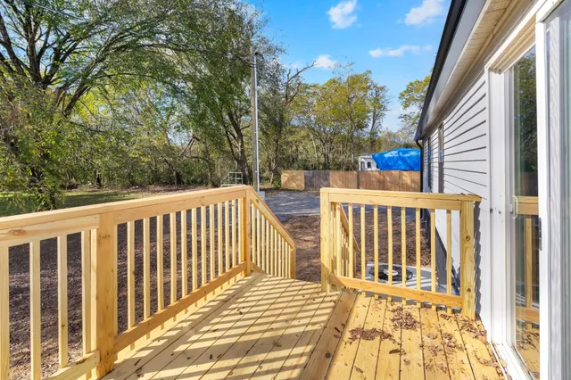 a view of a balcony with wooden floor and fence