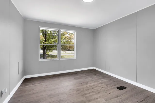 wooden floor in an empty room with a window