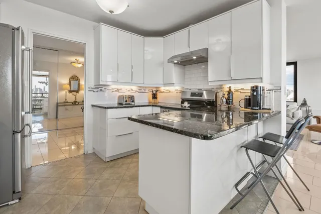 a kitchen with stainless steel appliances granite countertop a sink stove and cabinets