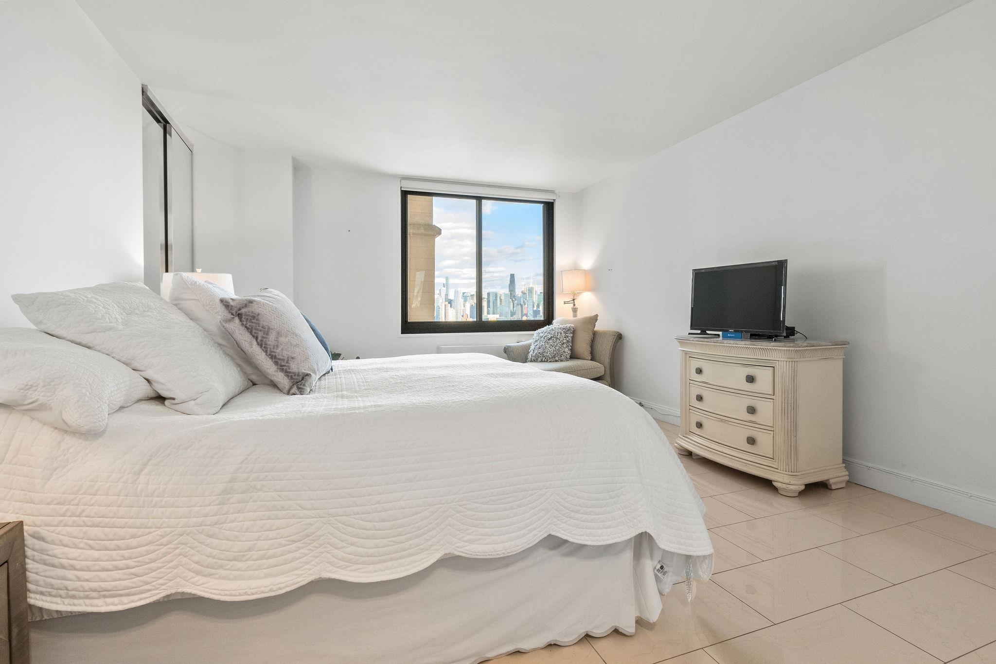 380 Mountain Road, Unit 612 Union City, NJ 07087 - Photo 25 of 45 a bedroom with a bed and a flat screen tv