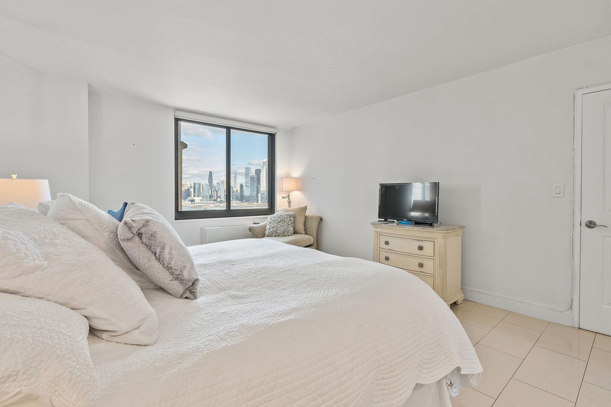 380 Mountain Road, Unit 612 Union City, NJ 07087 - Photo 26 of 45 a bedroom with a bed and a television