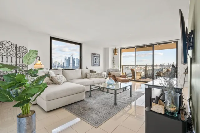 a living room with furniture and a large window with potted plants