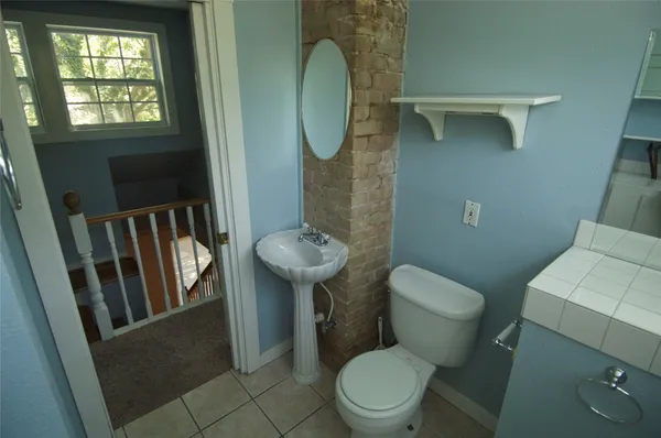 a white toilet sitting next to a bathroom sink and a mirror