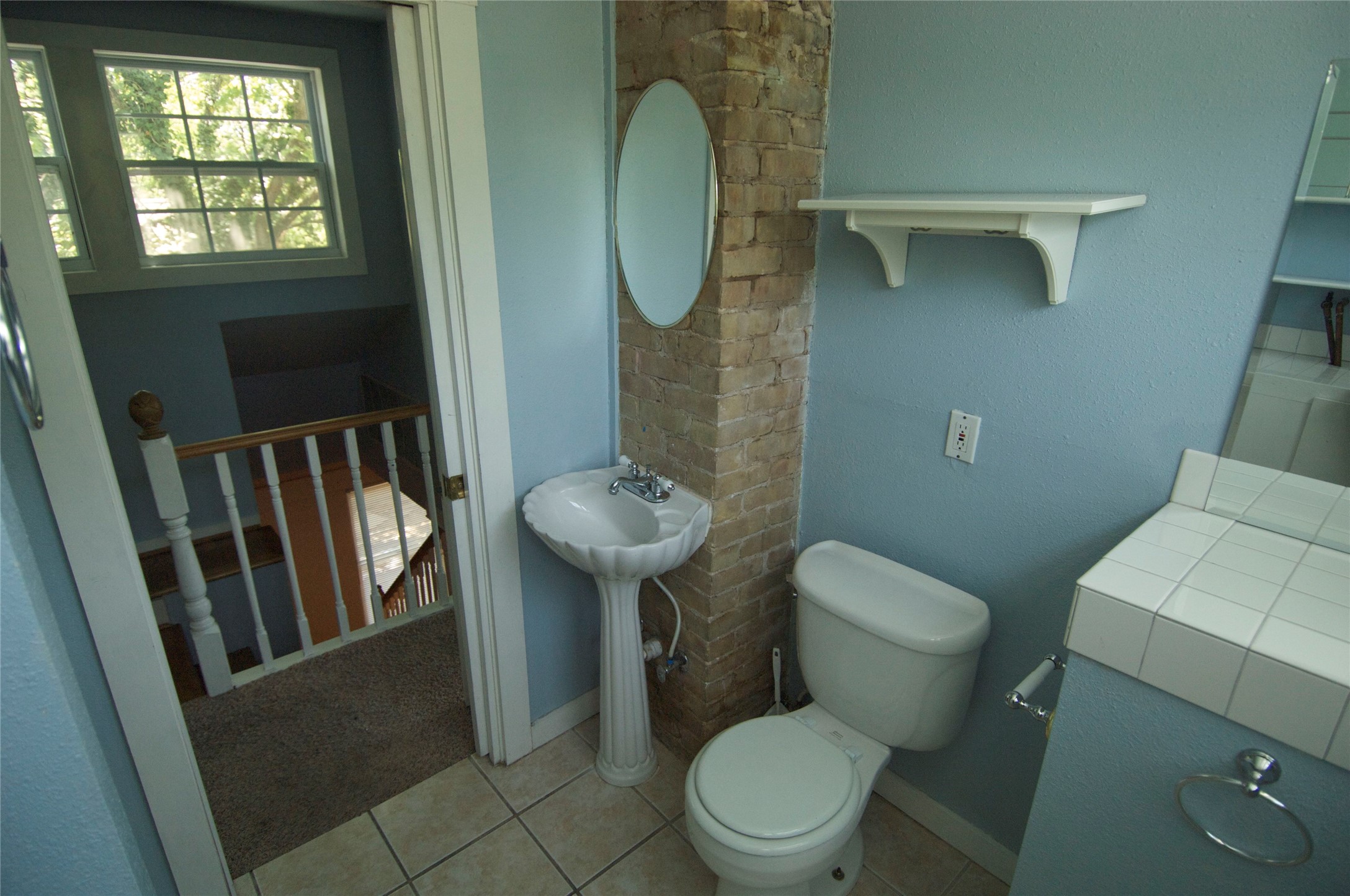 1107 West 22nd Street West, Unit A Austin, TX 78705 - Photo 11 of 15 a white toilet sitting next to a bathroom sink and a mirror