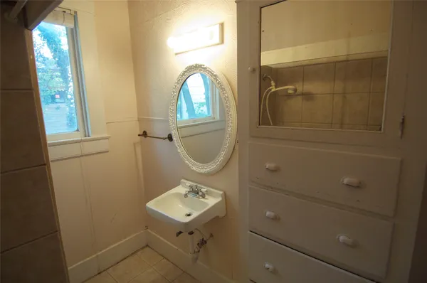 a bathroom with a sink a mirror and a window