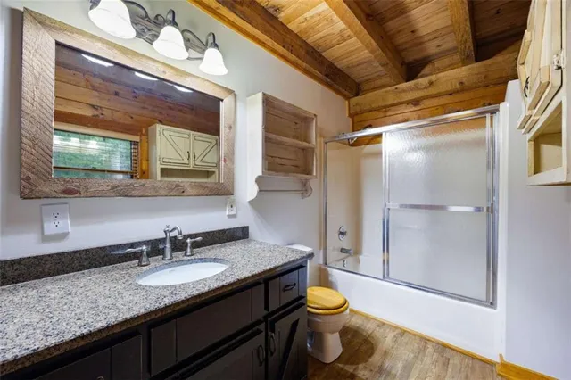a bathroom with a granite countertop sink toilet and shower