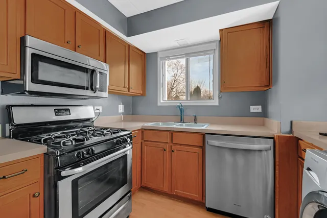 a kitchen with stainless steel appliances a stove microwave and sink