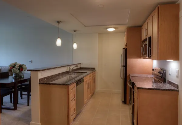 a kitchen with stainless steel appliances granite countertop a sink and a refrigerator