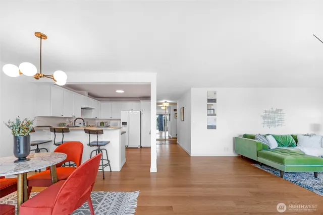 a living room with furniture a wooden floor and a chandelier