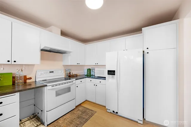 a kitchen with white cabinets and white appliances