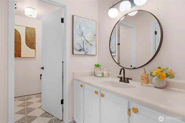 a bathroom with a sink mirror and vanity