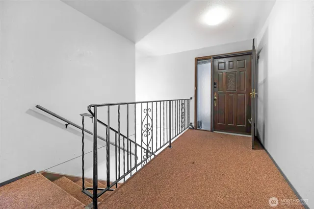 a view of a hallway with wooden floor and entryway