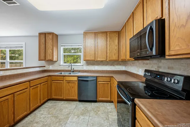 a kitchen with stainless steel appliances granite countertop a sink stove and cabinets