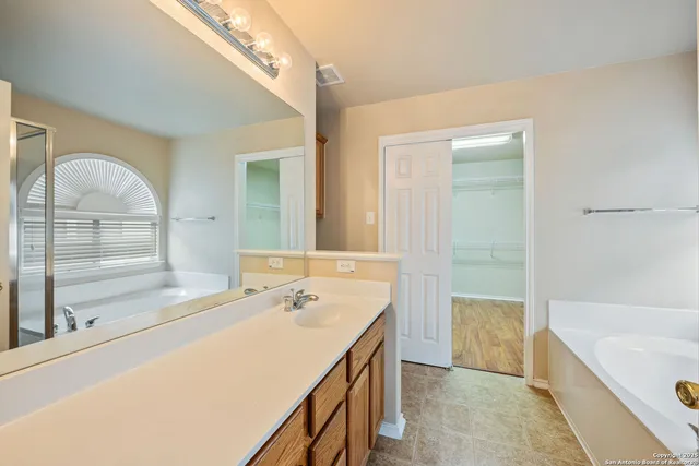 a bathroom with a tub sink and mirror