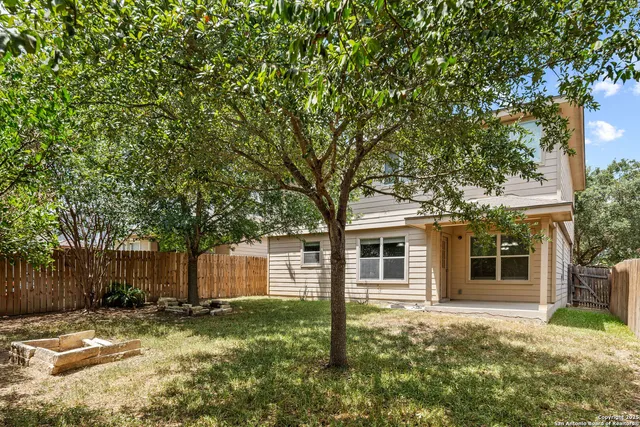 a backyard of a house with yard and tree