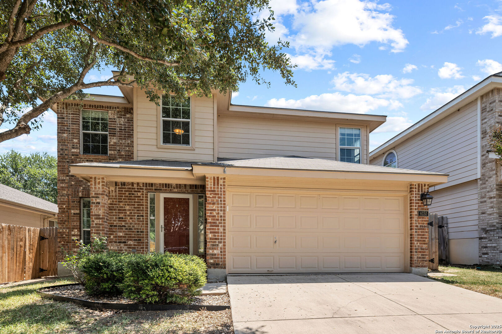 4030 Bear Oak Path San Antonio, TX 78223 - Photo 4 of 31 a view of a white house with large windows and a tree