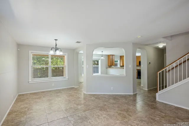an empty room with windows and chandelier