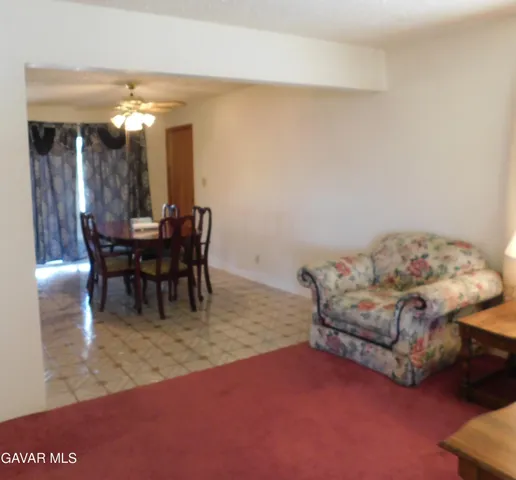 a living room with furniture a dining table and a chandelier